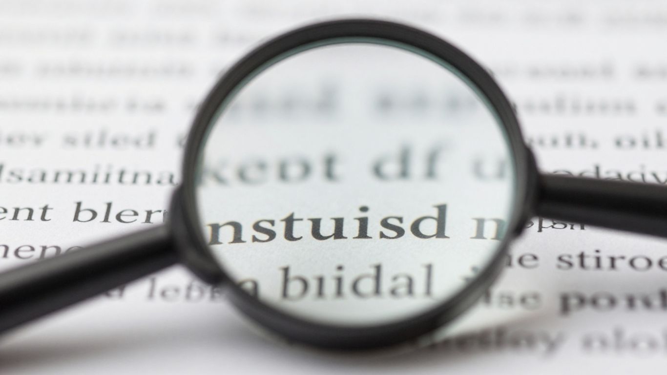 Magnifying glass over small words, SEO keywords